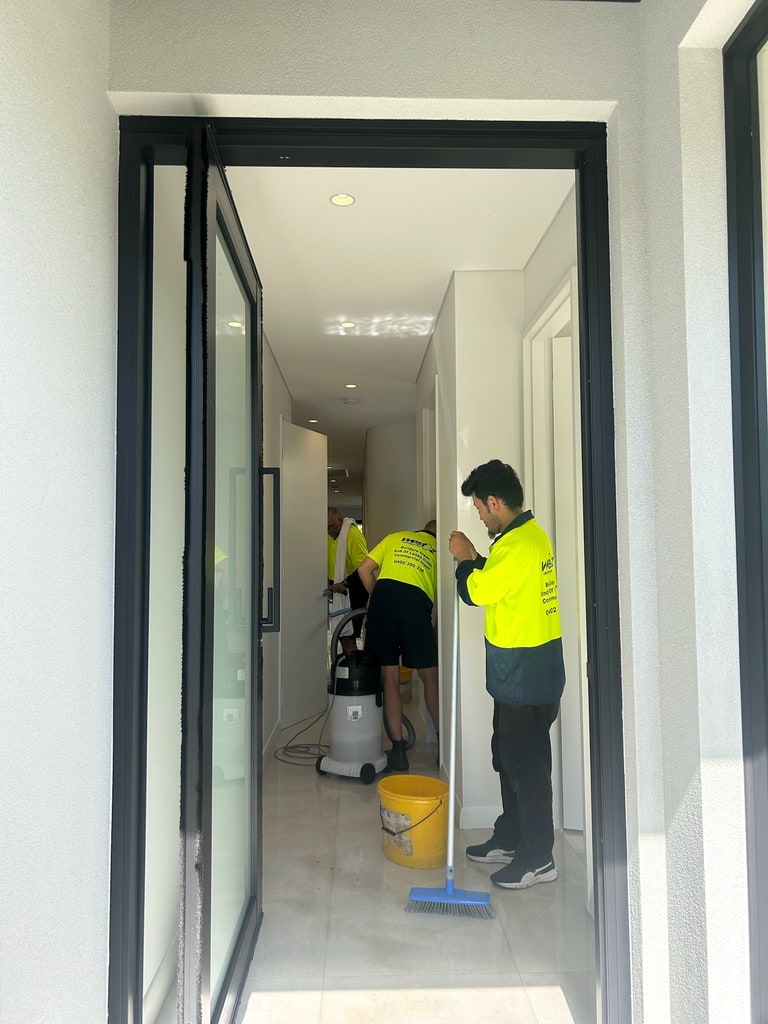 WOCS cleaners working near a doorway with cleaning equipment